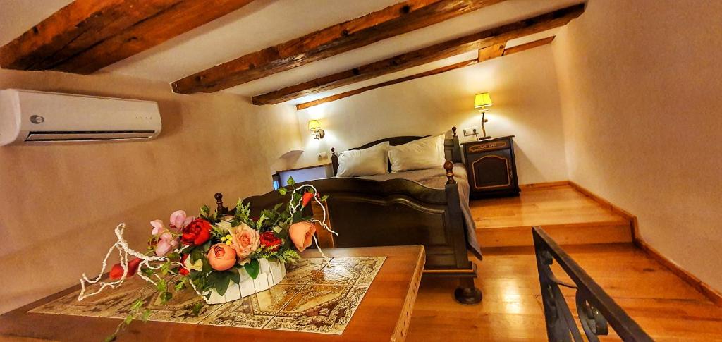 a room with a bed and a table with flowers on it at Casa Crown in Braşov