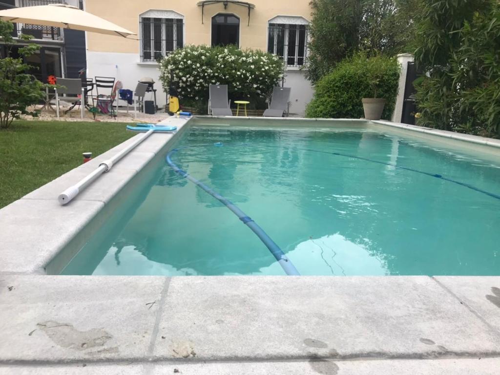 une piscine avec de l'eau bleue dans une cour dans l'établissement Villa au centre de Nîmes, à Nîmes