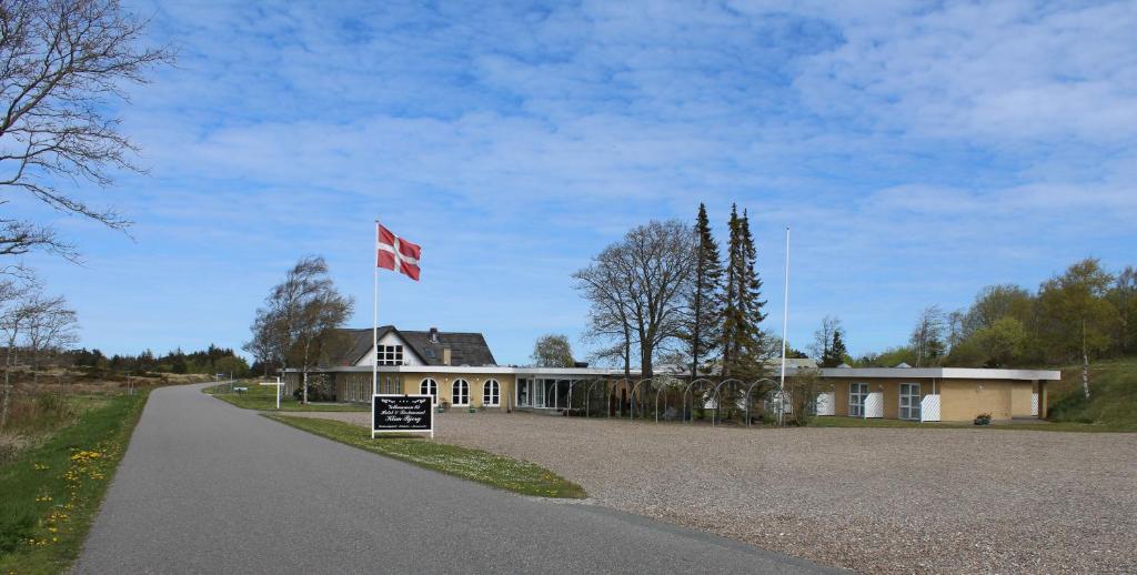 a house with a canadian flag on the side of a road at Hotel Klim Bjerg in Fjerritslev