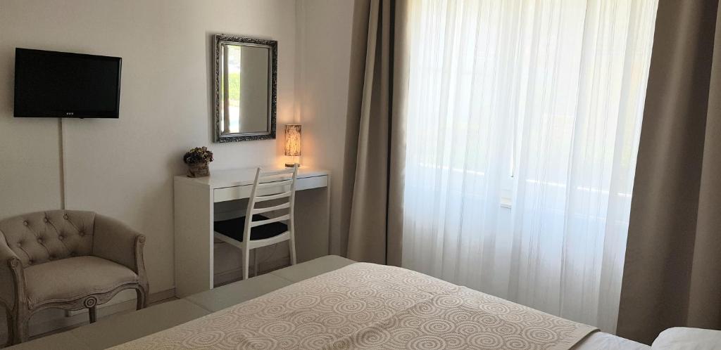a bedroom with a bed and a chair and a mirror at Boutique Villa Revelin in Pag