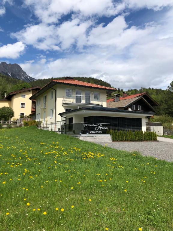 a house with a field of grass and flowers at Appartementhaus Anna in Leogang