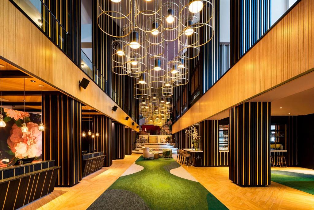 a lobby with a large chandelier and a green carpet at The Starling Atlanta Midtown, Curio Collection by Hilton in Atlanta