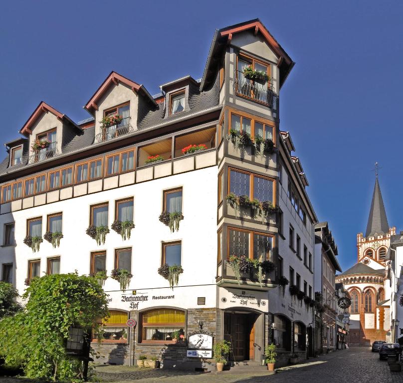 un edificio blanco alto con ventanas y plantas. en Bacharacher Hof, en Bacharach