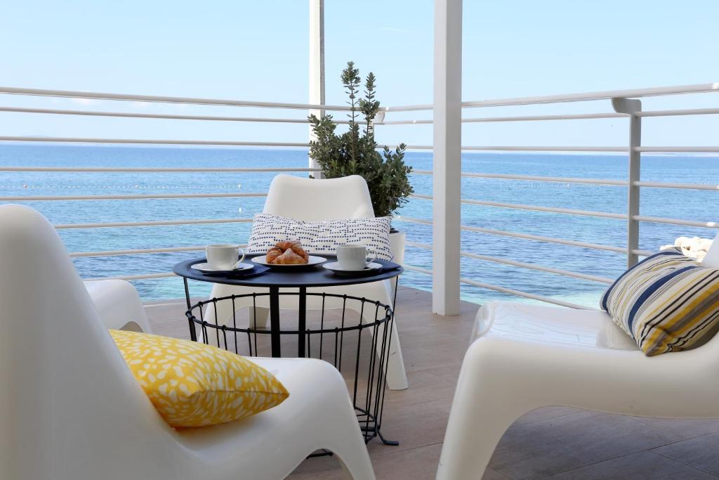 a balcony with a table and chairs and the ocean at Beach Rooms Split in Podstrana