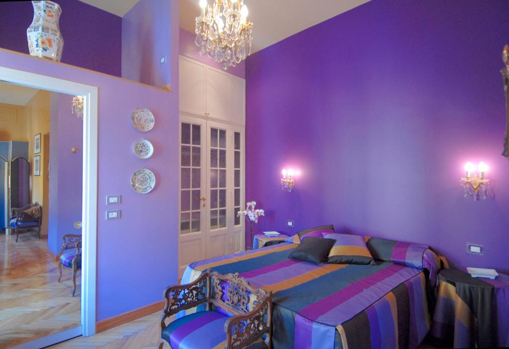 - une chambre violette avec un lit et un lustre dans l'établissement Suite Casa Pariolina, à Rome