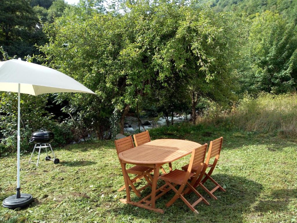 une table et des chaises avec un parasol et un grill dans l'établissement Ax Sweet Mountain - 3ch et 2 sdb - jardin centre village, à Ax-les-Thermes