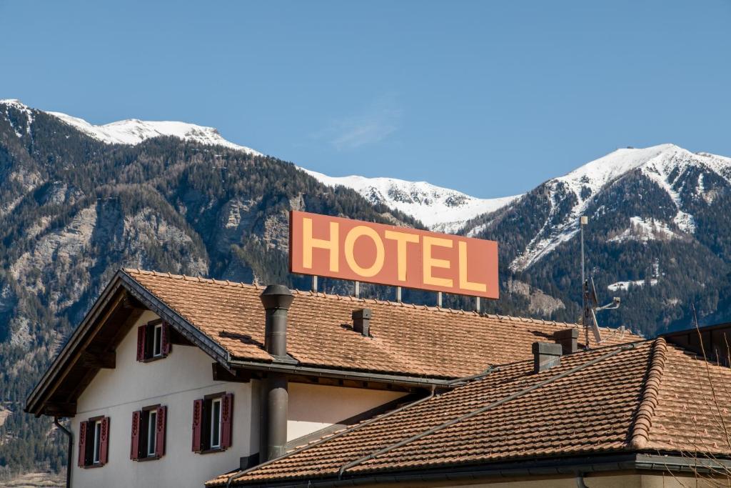 un panneau d'hôtel au-dessus d'un bâtiment avec des montagnes dans l'établissement Hotel Reich, à Cazis
