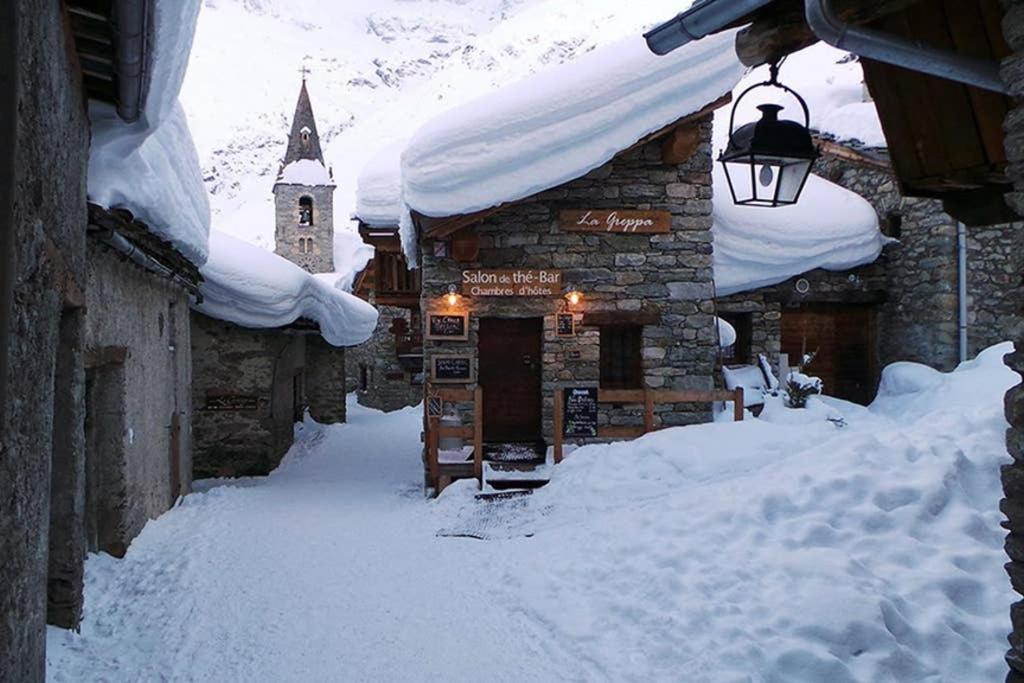 budynek pokryty śniegiem ze światłem i lampą w obiekcie Chalet à la montagne 10 places 4 chambres w mieście Bonneval-sur-Arc