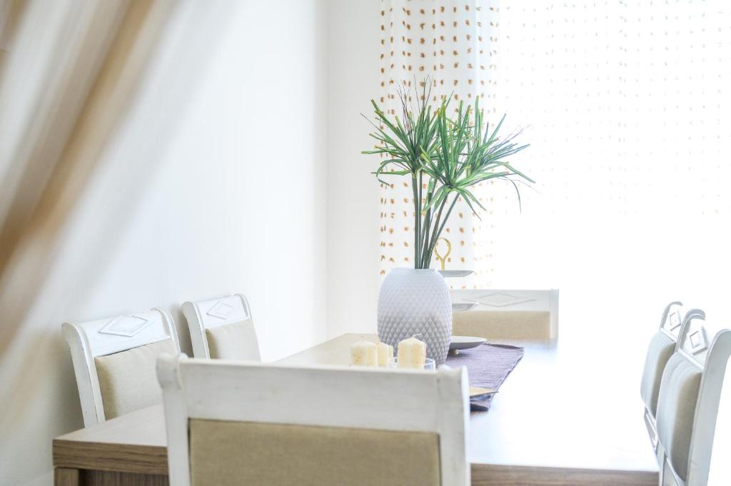a dining room with a table with chairs and a plant at Luxury House in Vrachati