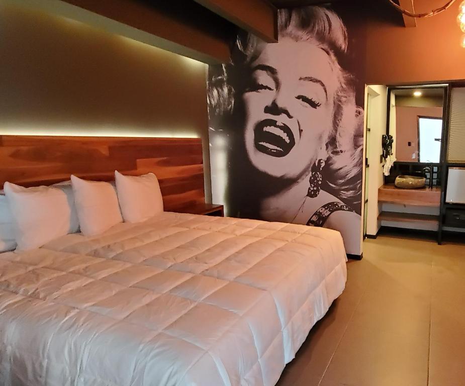 een slaapkamer met een bed met een grote poster van een vrouw bij HOTEL RIO RITA in Tijuana