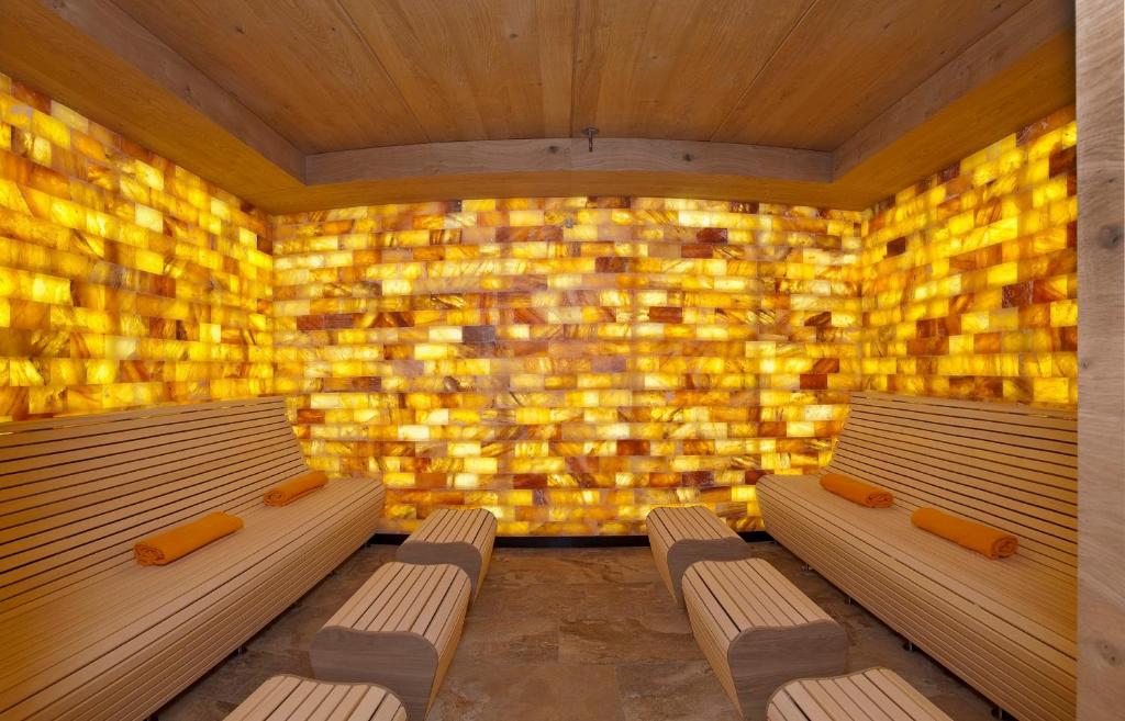two benches in a room with a wall of yellow bricks at Verwöhnhotel Kristall in Pertisau