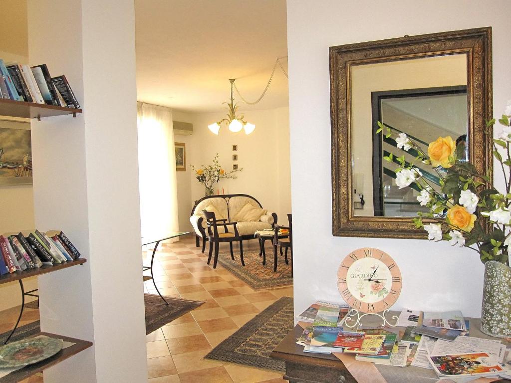 a living room with a mirror and a table with books at Magralù 2 B&B in Alghero