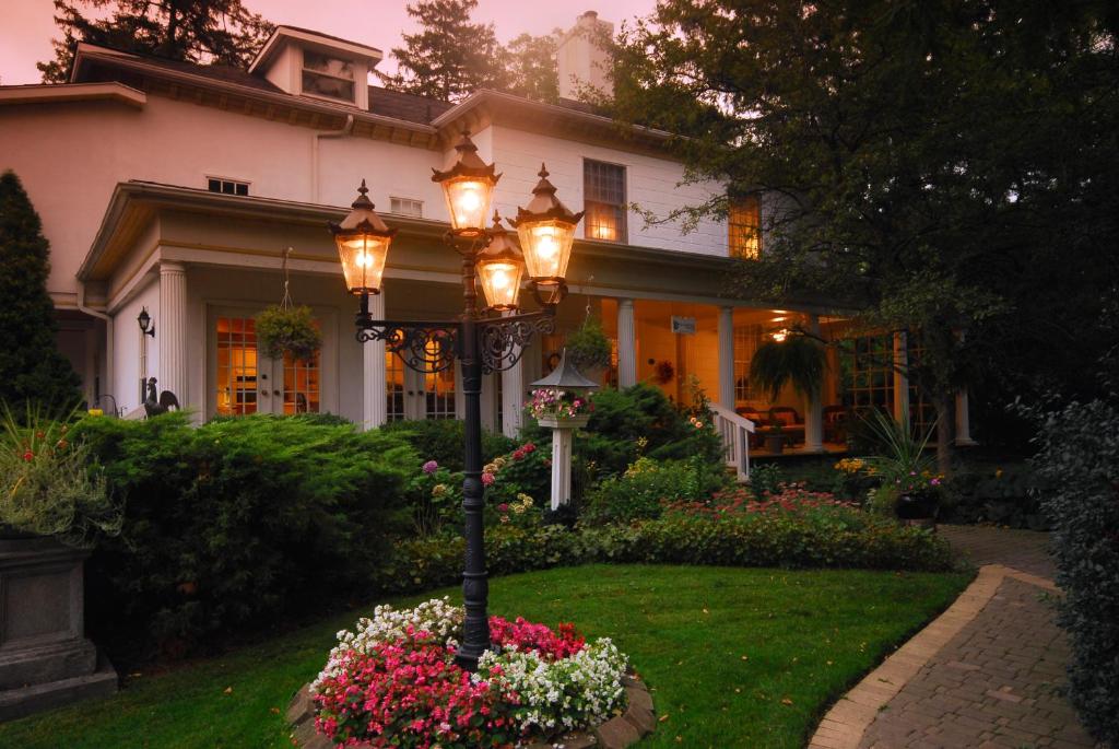 a lamp post in front of a house with flowers at Brockamour Manor Bed and Breakfast in Niagara on the Lake