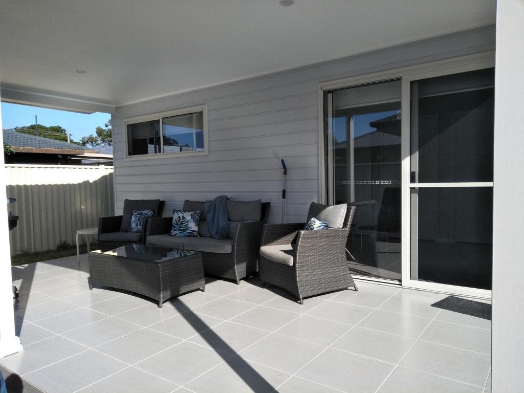 a patio with chairs and a couch and a table at Ashley's Retreat Umina Beach in Umina