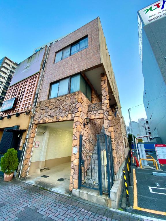 a brick building with a garage on a street at Villa Monica in Nagoya