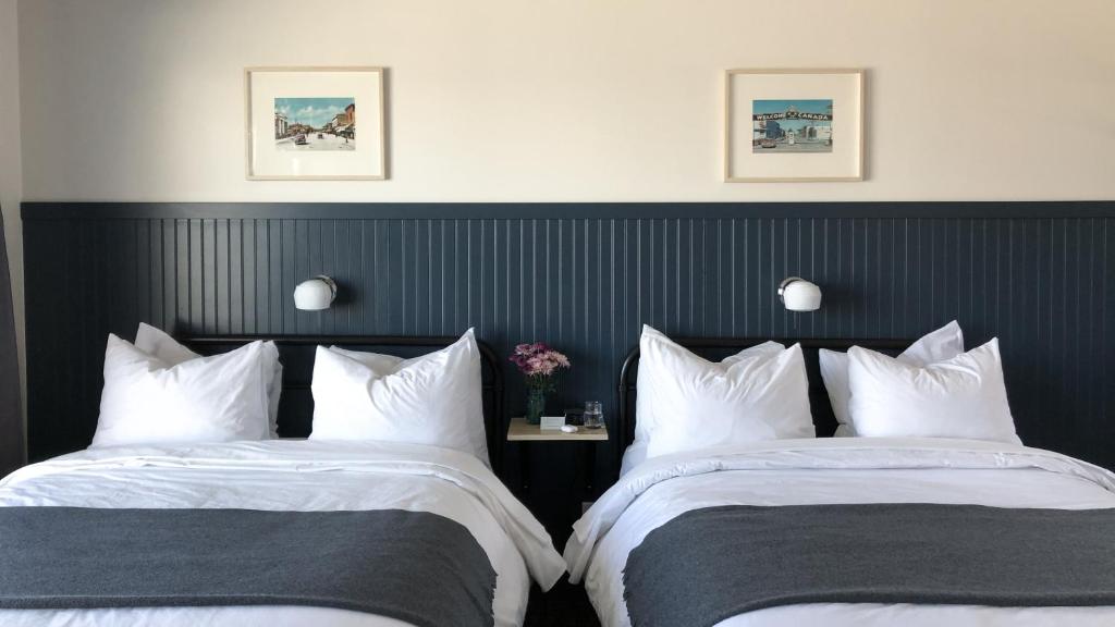 two beds sitting next to each other in a room at The Bayview Motel - Fort France, ON - Lakeside Motel in Fort Frances