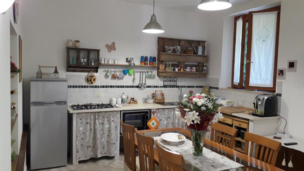 eine Küche mit einem Tisch und einer Blumenvase darauf in der Unterkunft La casa di Eva in Castel Viscardo