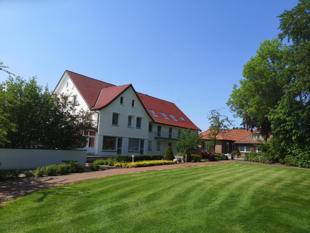 ein großes weißes Haus mit einem großen grünen Hof in der Unterkunft Haus Sonnenwinkel in Bad Laer
