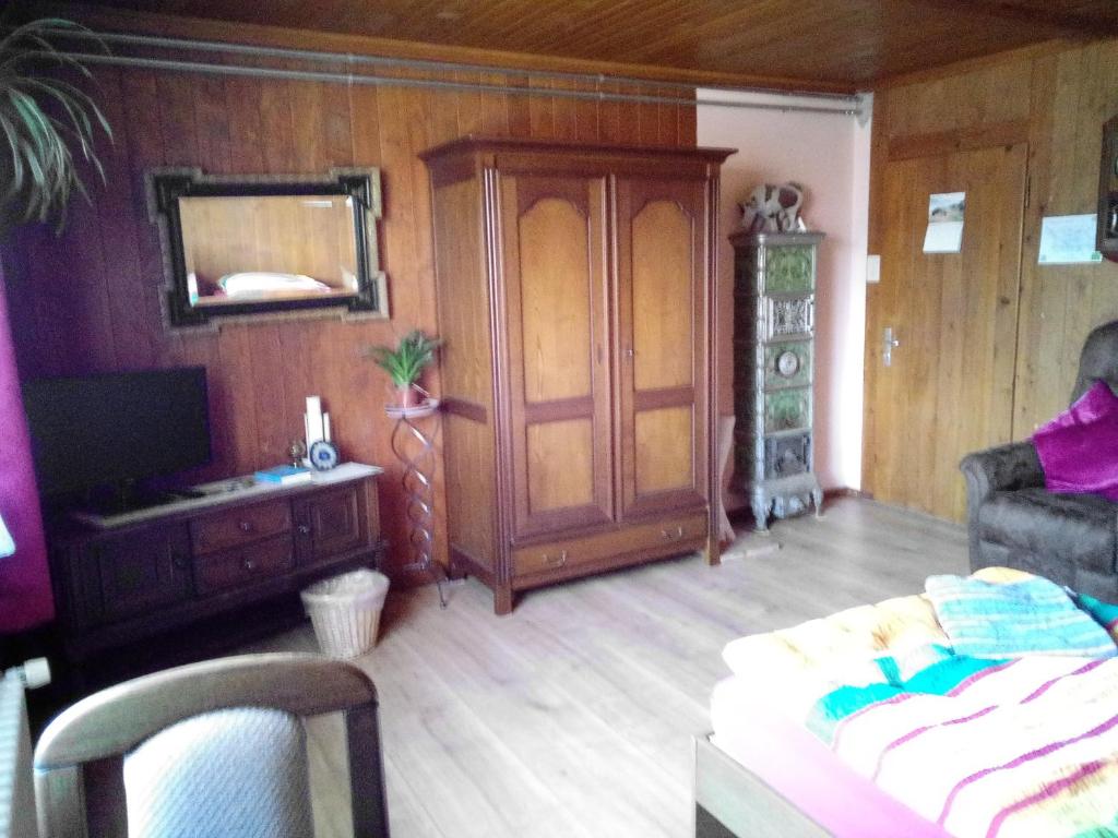 ein Wohnzimmer mit einem Sofa, einer Kommode und einem Spiegel in der Unterkunft Chambre d'hôtes Petit Martel in Les Ponts-de-Martel