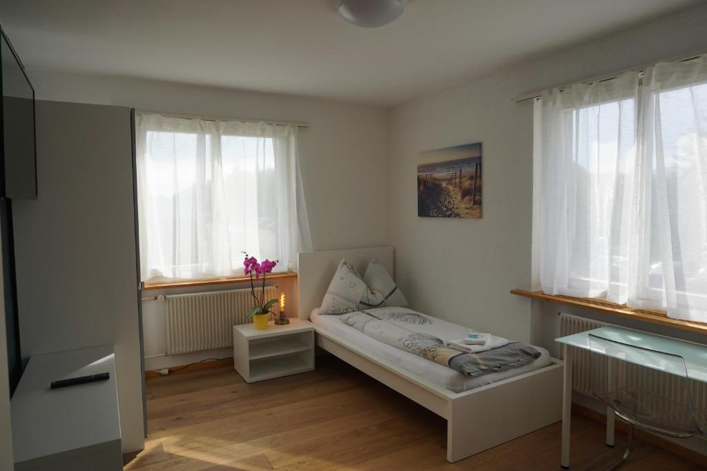 a small bedroom with a bed and two windows at good bed wynau in Wynau
