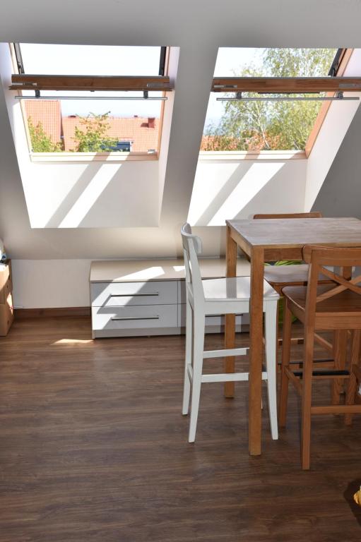 a dining room with a table and chairs and two windows at Nidos Horizontas in Neringa