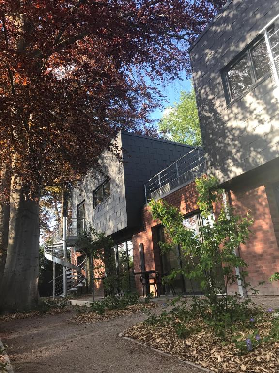 - une vue sur l'extérieur d'un bâtiment avec un arbre dans l'établissement Gites du bien-hêtre, à Saint-Amand-les-Eaux