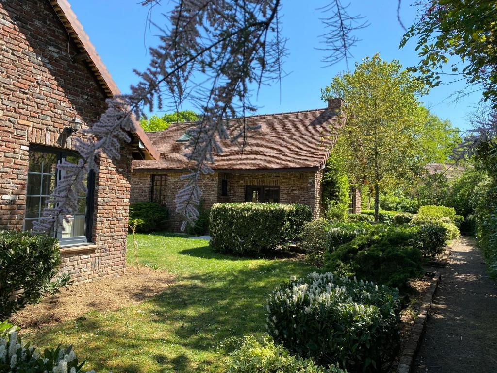 een stenen huis met een tuin met struiken bij Les Cottages d'Orient Premium in Mesnil-Saint-Père