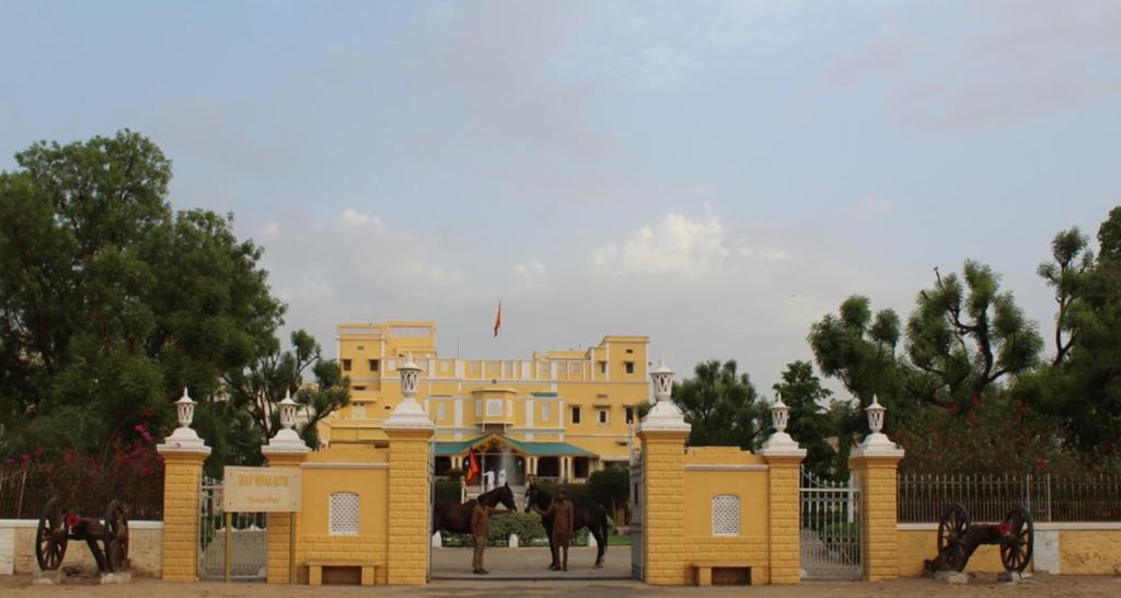 un edificio amarillo con caballos delante en Roop Niwas Kothi, Near Mandawa, en Nawalgarh