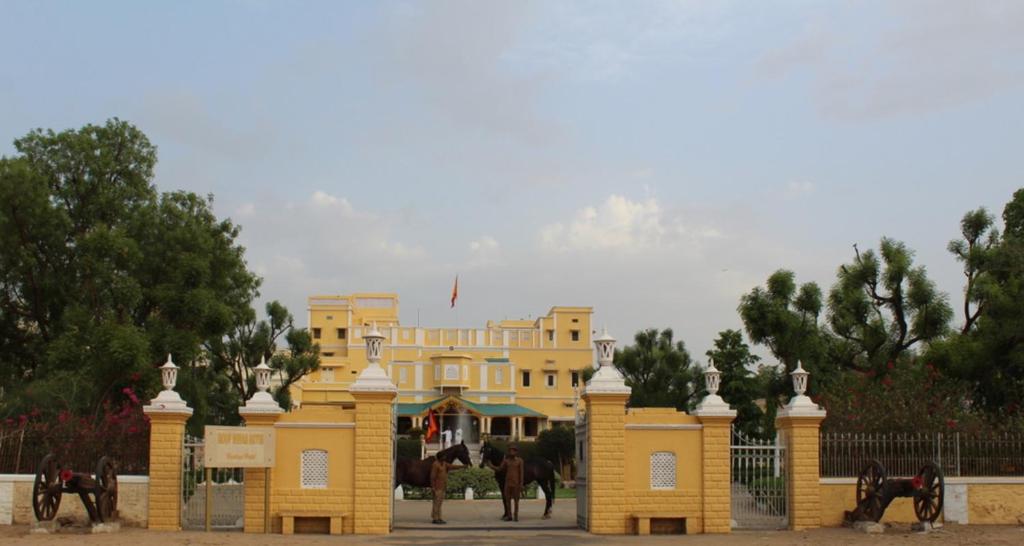 ein gelbes Gebäude mit Pferden davor in der Unterkunft Roop Niwas Kothi, Near Mandawa in Nawalgarh