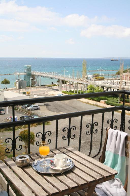 a table on a balcony with a view of the ocean at Chrielka Hotel in Limassol