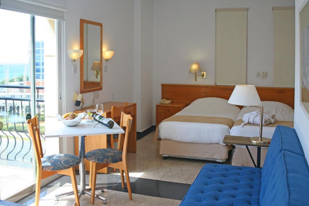 a hotel room with a bed and a table and chairs at Chrielka Hotel in Limassol