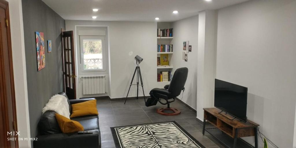uma sala de estar com um sofá e uma televisão em Casa de la Abuela en el Camino de Santiago a Finiesterre em Negreira