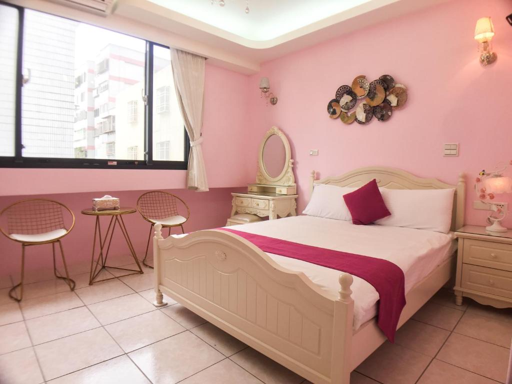 a bedroom with a bed with pink walls and windows at Hualien Dawan B&amp;B in Ji&#39;an