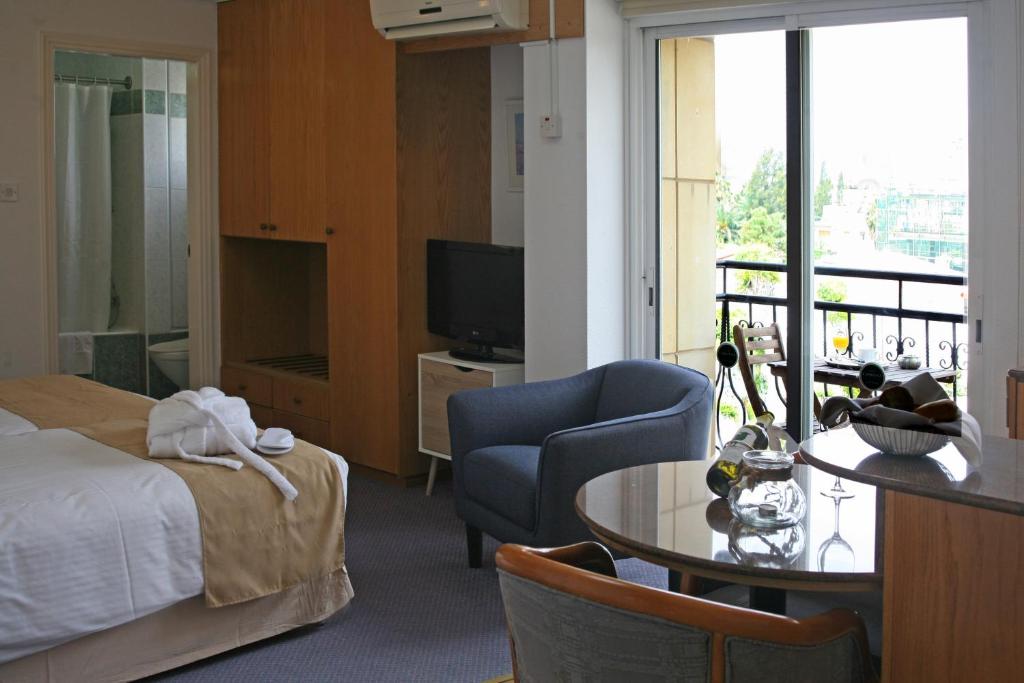 a hotel room with a bed and a table and a television at Chrielka Hotel in Limassol