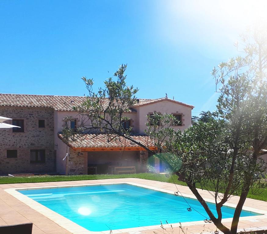 Villa con piscina frente a una casa en La Masia de Montpedrós en Peralada