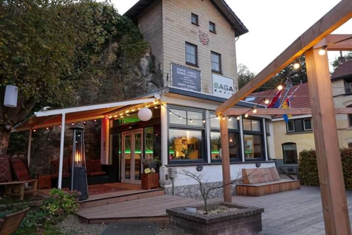 un bâtiment avec une terrasse en bois devant lui dans l'établissement Saga and More B&B Brasserie, à Berg en Terblijt