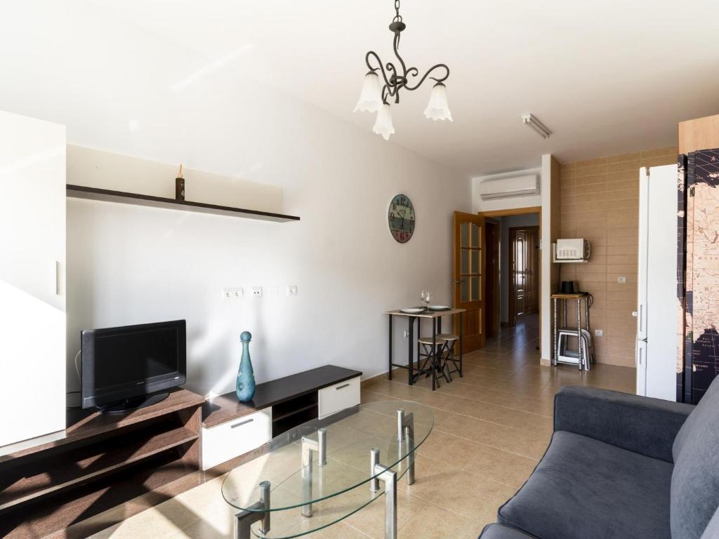 sala de estar con sofá azul y TV en Belvilla by OYO Apartment in Roquetas de Mar en Aguadulce