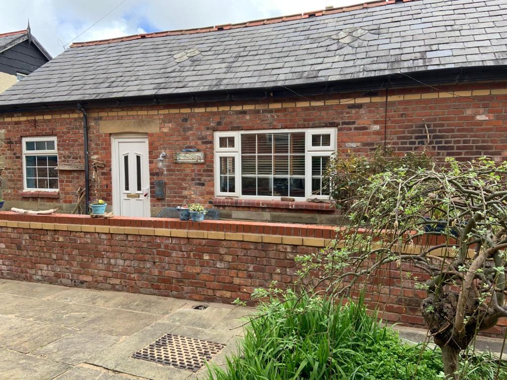 a brick house with a white door and window at Beach Cottage in Lytham St Annes