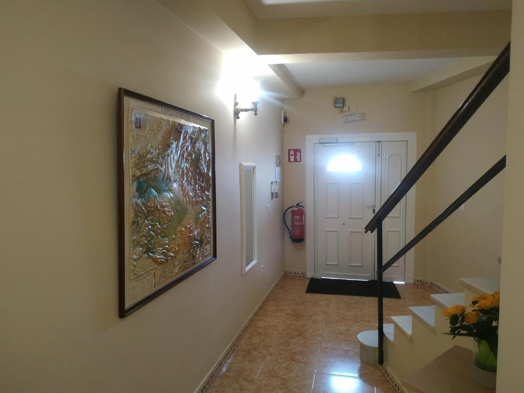 a hallway with a painting on the wall and a staircase at Hostal El Rincón - Casa Marcos in Yepes