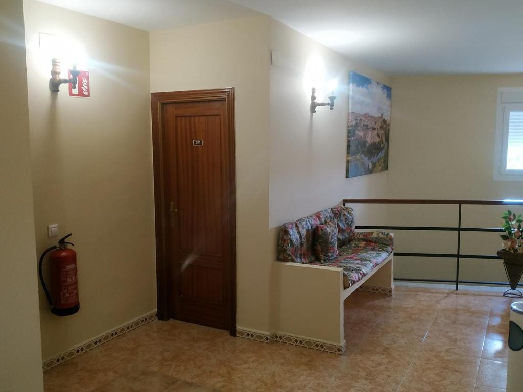 a waiting room with a bench and a door at Hostal El Rincón - Casa Marcos in Yepes