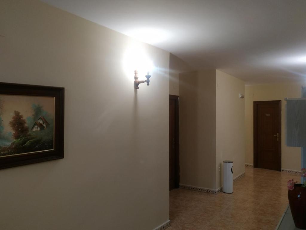 a room with a light on a wall with a picture at Hostal El Rincón - Casa Marcos in Yepes