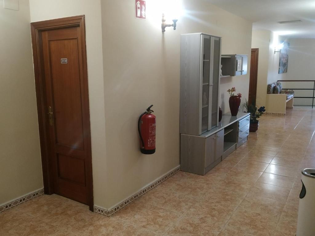 a living room with a fire extinguisher on the wall at Hostal El Rincón - Casa Marcos in Yepes