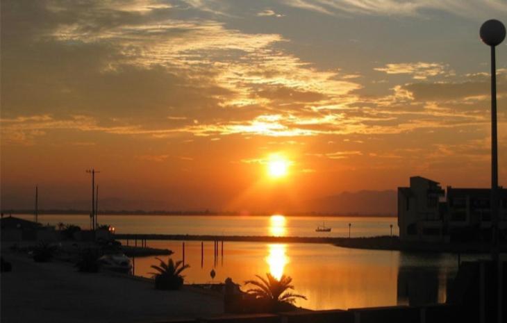 a sunset over a large body of water at Agréable studio Barcares in Le Barcarès