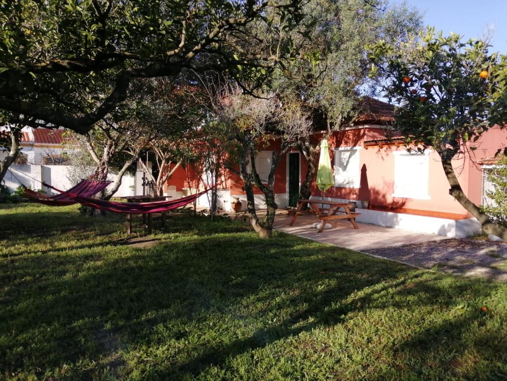 a hammock in the yard of a house at Casa das Laranjeiras e parque infantil in Villa Nogueira