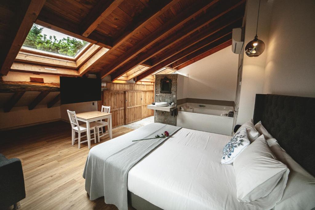 ein Schlafzimmer mit einem großen weißen Bett und einem Tisch in der Unterkunft Posada La Corralada in Pámanes