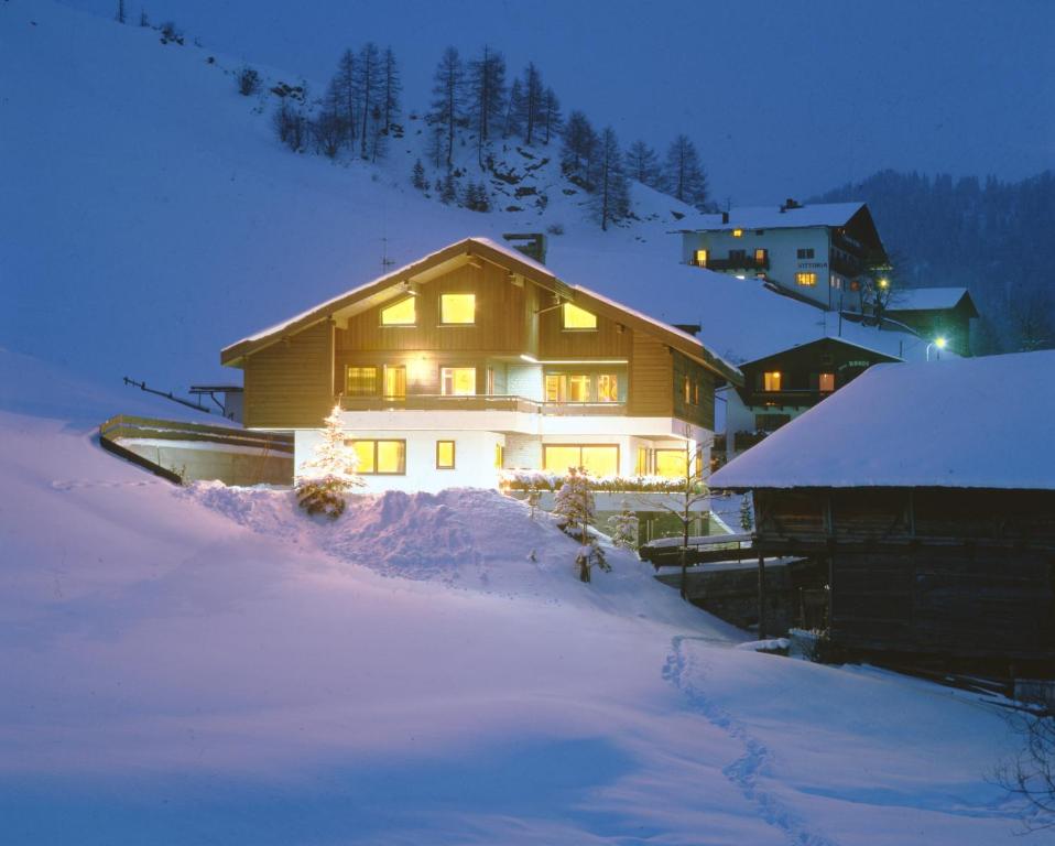 ein Haus im Schnee in der Nacht in der Unterkunft Apartments Residence Alta Badia in Kolfuschg