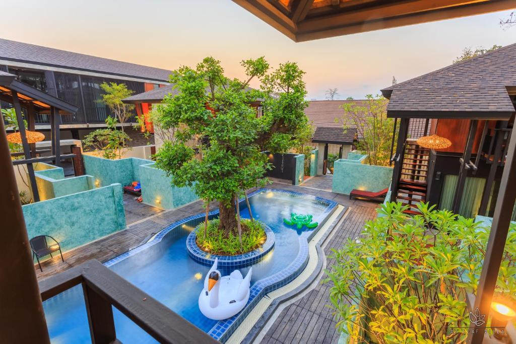 an indoor garden with a tree in a pool at At Leaf Villa in Chiang Mai