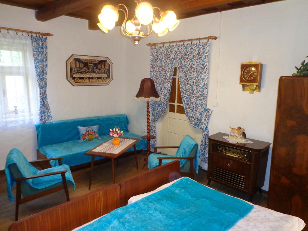 sala de estar con sofá, mesa y sillas en Nevšední ubytování jako u babičky ve stylu 60.let, en Budkovce