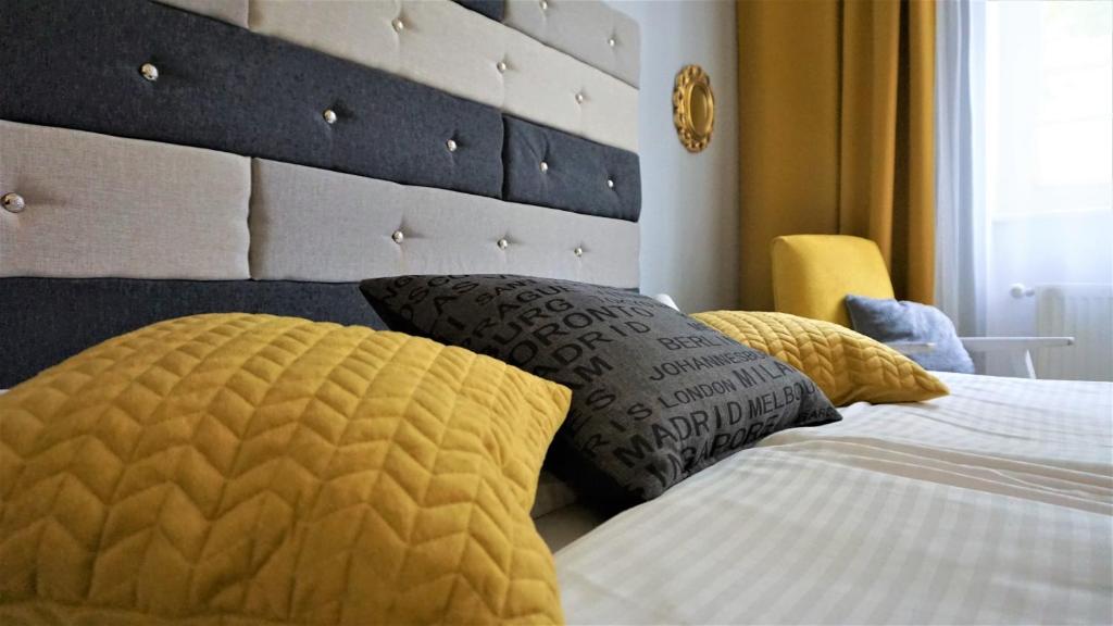 a bedroom with a bed with yellow and white pillows at Explorer Hostel & Apartment Stare Miasto OLD TOWN 24H in Poznań