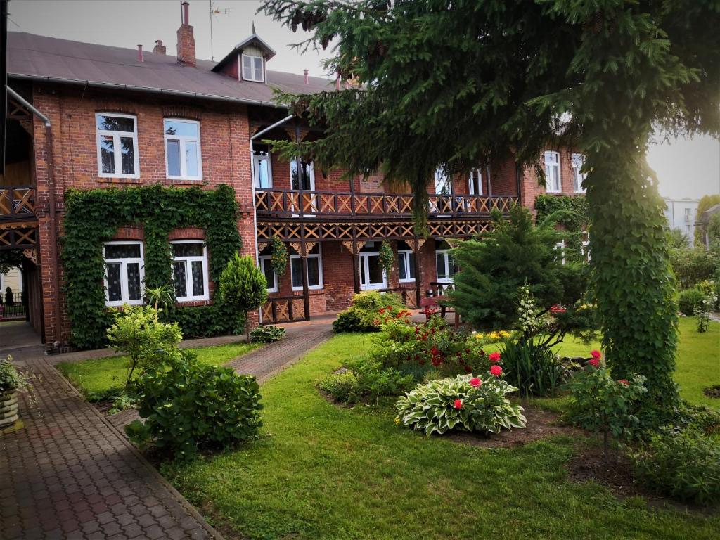 ein Backsteinhaus mit Garten davor in der Unterkunft Ośrodek Wypoczynkowy Janówka in Ciechocinek